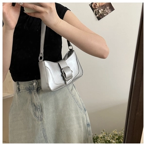 Silver metallic baguette bag with oversized buckle shown on shoulder in mirror selfie