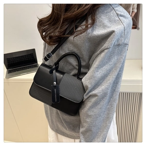 Détail du sac rectangulaire bicolore avec texture tissée grise et étiquette logo