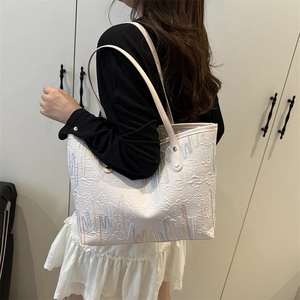 Fashionable beige tote bag with colorful wave embroidery and textured surface pattern
