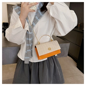 Detailed shot of contrast color straw handbag with orange leather and gold metal handle