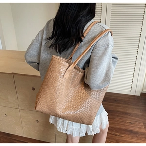 Gros plan montrant la texture tressée détaillée sur la surface du sac cabas marron