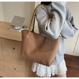 Gros plan détaillé d'un grand sac cabas tressé caramel dans un cadre professionnel chic