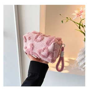 Pink lamb wool handbag featuring 3D heart pattern and purple plush strap detail