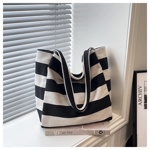 Detailed close-up of striped canvas tote bag showing thick texture and fabric handle