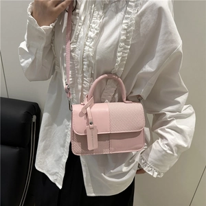 Mini sac bandoulière rose en cuir lisse et texture tissée porté par un mannequin