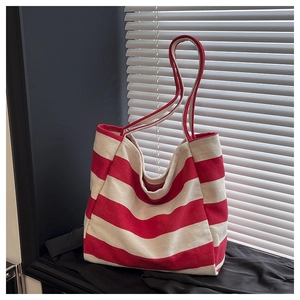 Detailed texture of a red and white striped canvas tote bag with reinforced handles