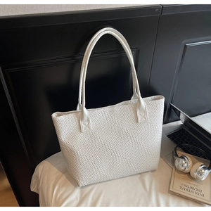 Détail du sac cabas blanc à texture tressée avec arrière-plan de bureau minimaliste