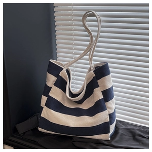 Detail of nautical navy and white striped canvas tote bag with thick rope handles