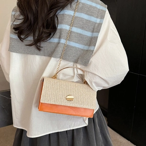 Fashionable woven crossbody bag with orange leather and golden metal handle on a model