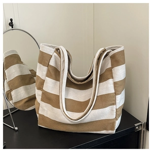 Close-up of striped canvas tote bag with thick brown and white textured fabric strap
