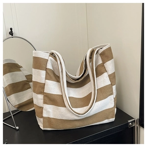 Detail of striped canvas tote bag showing thick fabric texture and wide shoulder straps