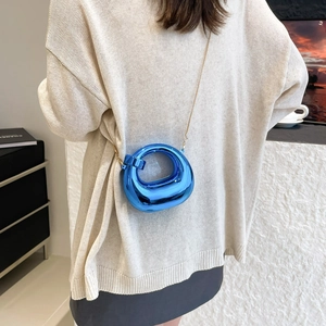Electric blue metallic crescent mini bag with gold chain strap on shoulder