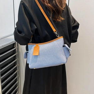 Blue and white canvas tote bag with brown leather trim and metal zipper accents