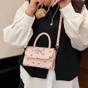 Sac bandoulière rose à motif nœuds avec boucle argentée et bandoulière réglable