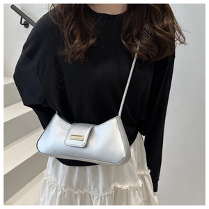 Silver metallic baguette bag with golden buckle styled on a white stairway background