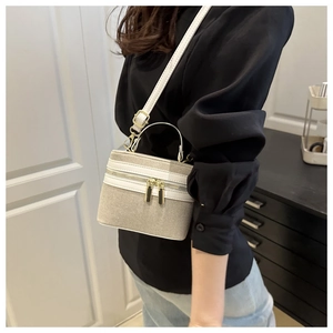 Mini box bag in beige canvas and white leather trim worn as a stylish crossbody crossbody