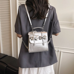 Metallic silver mini backpack with bow detail and pearl charm for fashionable women