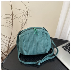 Détail d'un sac bandoulière en velours côtelé avec double zip et sangle réglable