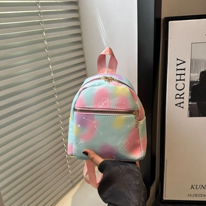 Detail of a mini tie-dye backpack featuring a colorful heart pattern and gold zipper closure