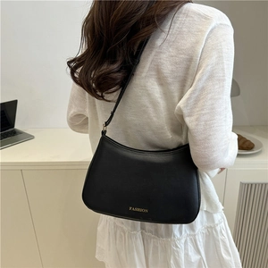 Sac hobo minimaliste noir avec texte doré sur un modèle pour le quotidien chic
