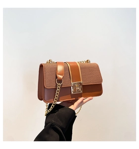 Detail of a brown patchwork crossbody bag with gold square buckle and chain strap
