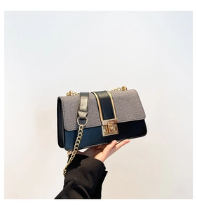 Close-up of minimalist crossbody bag with grey woven texture and gold chain strap