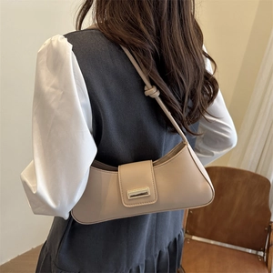 Minimalist beige leather baguette bag with golden buckle and knot detail shoulder strap