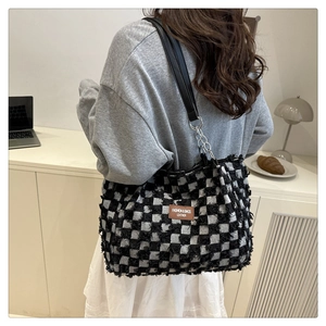 Detail of checkered tweed tote bag with fringe edges and leather chain shoulder strap