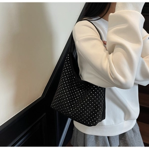 Detail of black denim hobo bag featuring sparkling silver rhinestones and soft suede finish