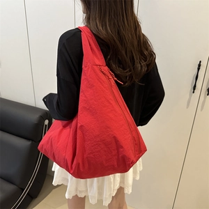 Large red nylon tote bag shown on shoulder for casual commuting and minimalist style