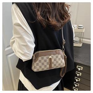 Detailed back view of a woman wearing a vintage plaid crossbody bag with a slim strap