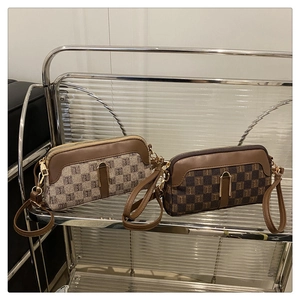 Detail of checkered canvas handbags with leather trim and gold metal zippers