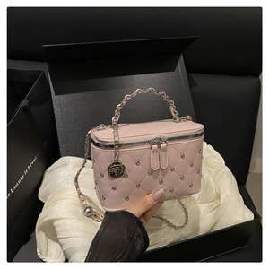 Macro detail of pink quilted leather vanity bag with silver beads and rose charm