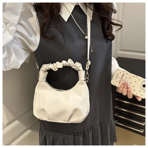 Detail of cream white crescent cloud bag showing pleated handle and soft leather texture