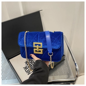 Close-up of Klein blue velvet crossbody bag with gold geometric lock and chain strap