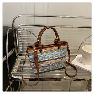 Close-up of multicolor woven bucket bag featuring brown leather knotted handle detail