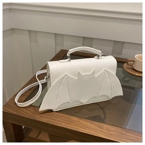 Detail of white PU leather crossbody bag featuring unique bat wing decor and silver hooks