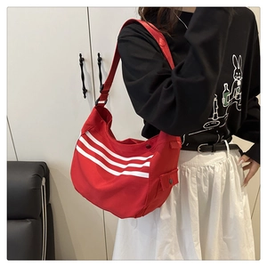 Détail du grand sac cabas en toile rouge avec trois bandes blanches et poche latérale