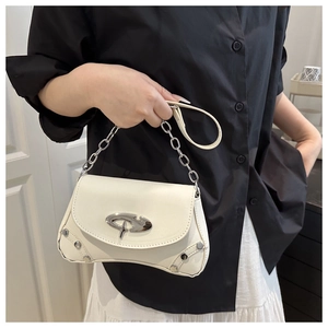 Detail of white leather shoulder bag featuring silver rivets and modern metal clasp