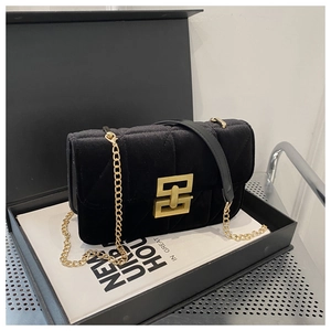 Detail of black quilted velvet shoulder bag with a bold gold geometric metal buckle