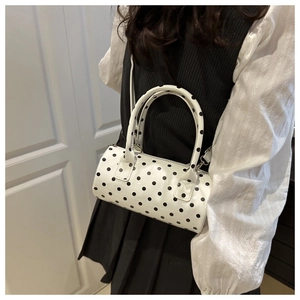 Polka dot cylinder shoulder bag worn by model showing mini size and retro style