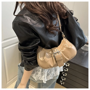 Detail of khaki glossy leather crescent bag with pleated bottom and silver metal buckle