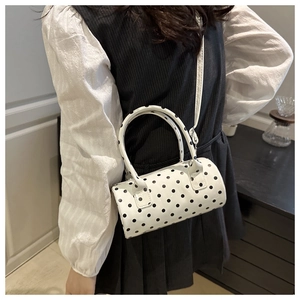 Gros plan détaillé d'un sac cylindrique blanc à pois noirs avec une texture fine en PU