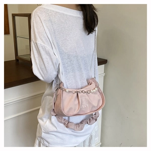 Détail du sac baguette plissé rose avec chaîne de perles et imprimé Look & Good