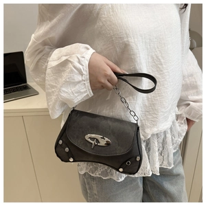 Detail of grey shoulder bag featuring star metallic buckle and silver rivet edges