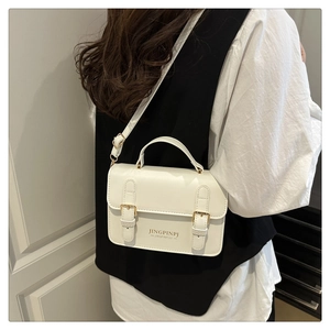 Detail of white mini crossbody bag with gold buckle and adjustable shoulder strap