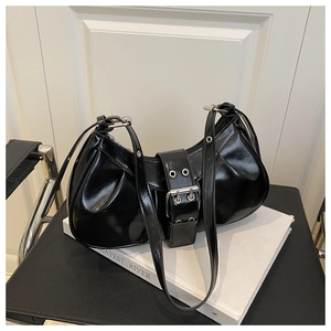 Detail of glossy black crescent bag featuring large silver buckle and adjustable strap