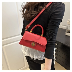 Retro red faux leather crossbody bag detail with bronze clasp and handle worn by model