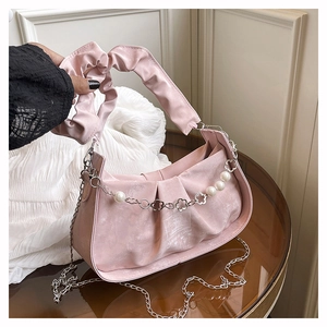 Détail du sac baguette plissé rose avec chaîne de perles et anse froncée