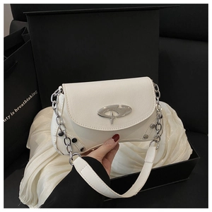 Detail of white leather shoulder bag with silver buckle on silk lining in a gift box